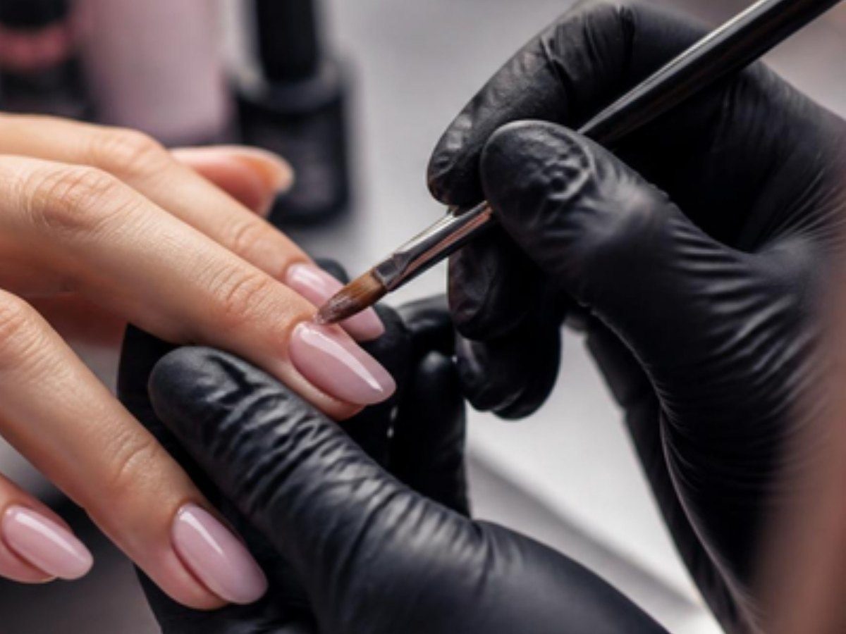 A nail artist's brush painting a design on a gel manicure (illustrative stock photo, not taken at Sunflower Nails with Hellen)